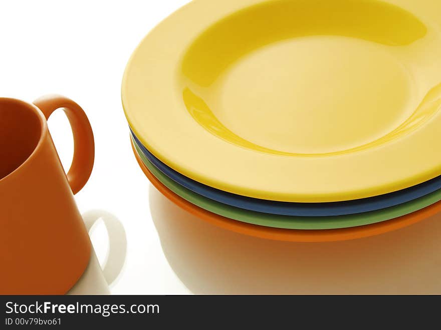 Closeup of a place setting with color ceramics plates and mug. Closeup of a place setting with color ceramics plates and mug