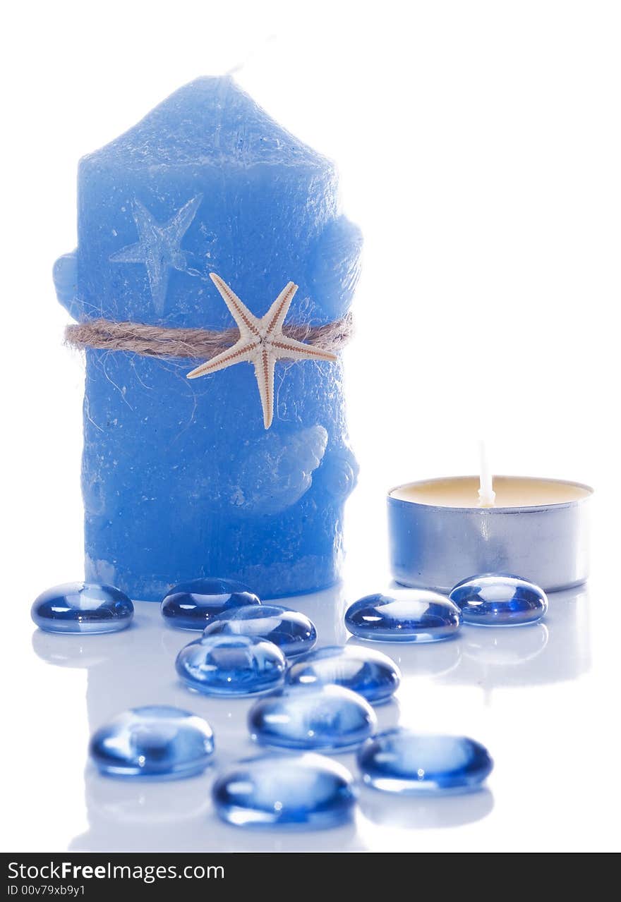 Blue candle and small candle and blue glass stones. Blue candle and small candle and blue glass stones