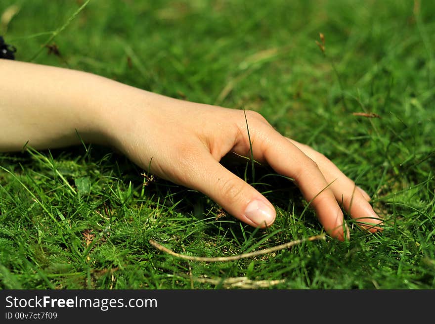 Relaxed hand on bed of grass