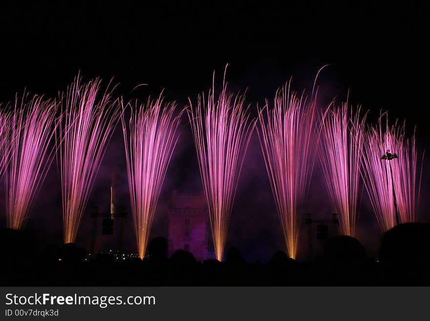 Colored fireworks in the night in lisbon near tower belem, portugal