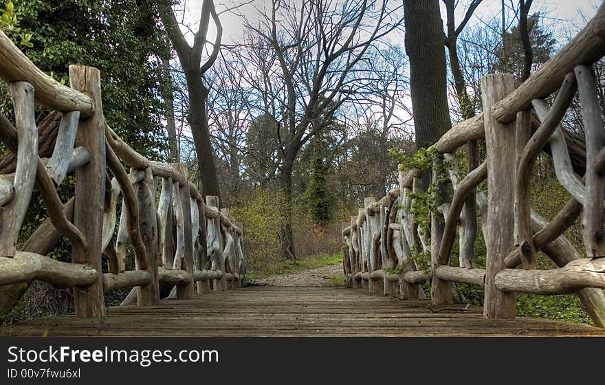 A small bridge made of wood with interesting handrail. A small bridge made of wood with interesting handrail