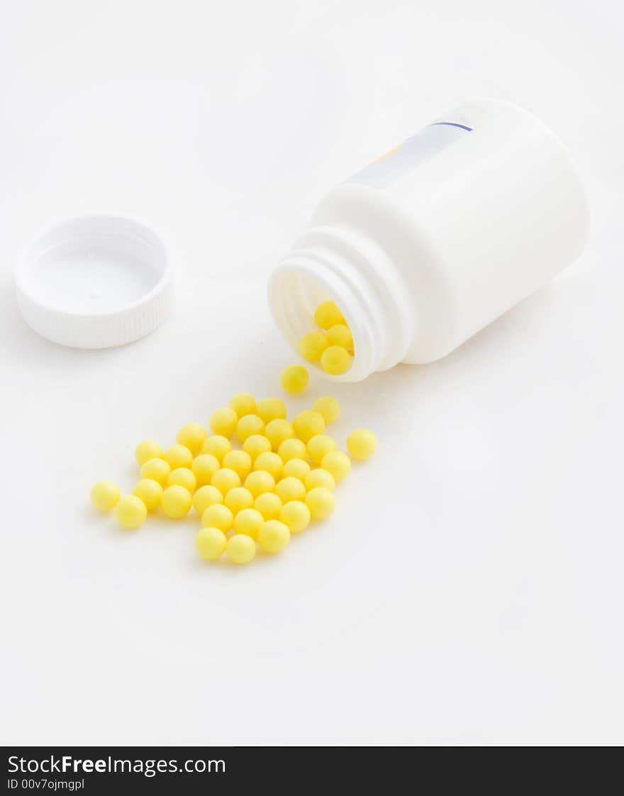 Yellow medicines were scattered from a white jar. Yellow medicines were scattered from a white jar