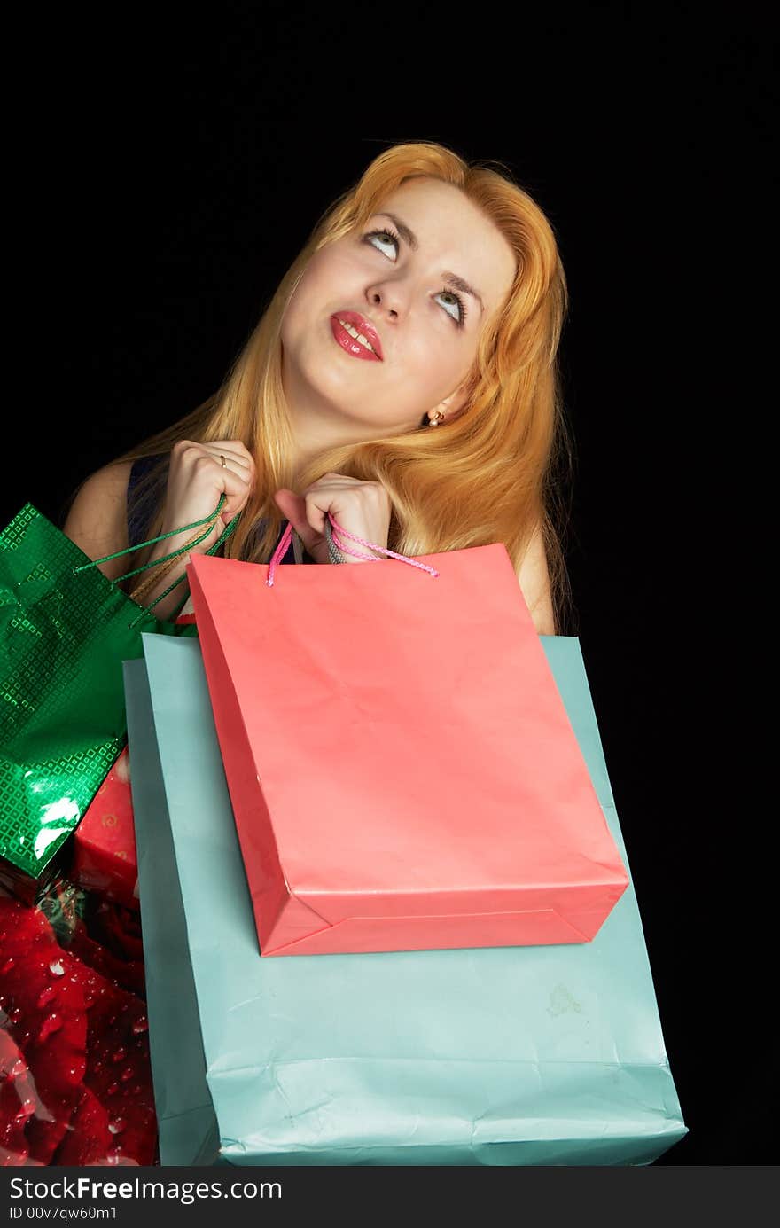 Blond girl with shopping bags over black background. Blond girl with shopping bags over black background