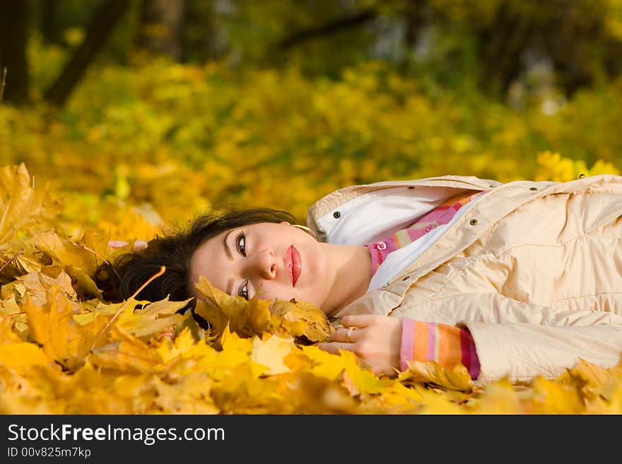 Young pretty woman on the autumn leaf