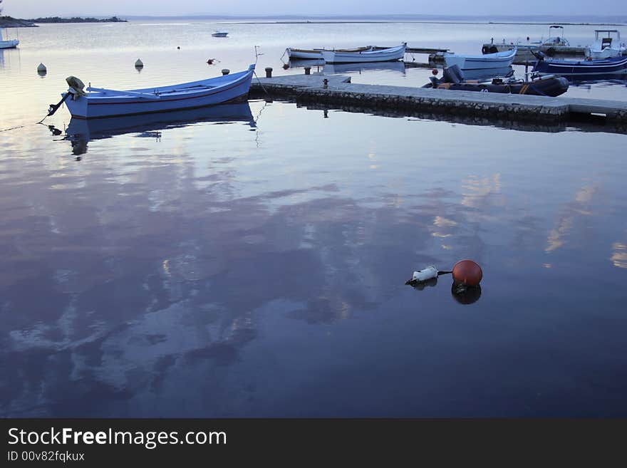 Quiet marina with sea reflecting the sky and clouds. Quiet marina with sea reflecting the sky and clouds.