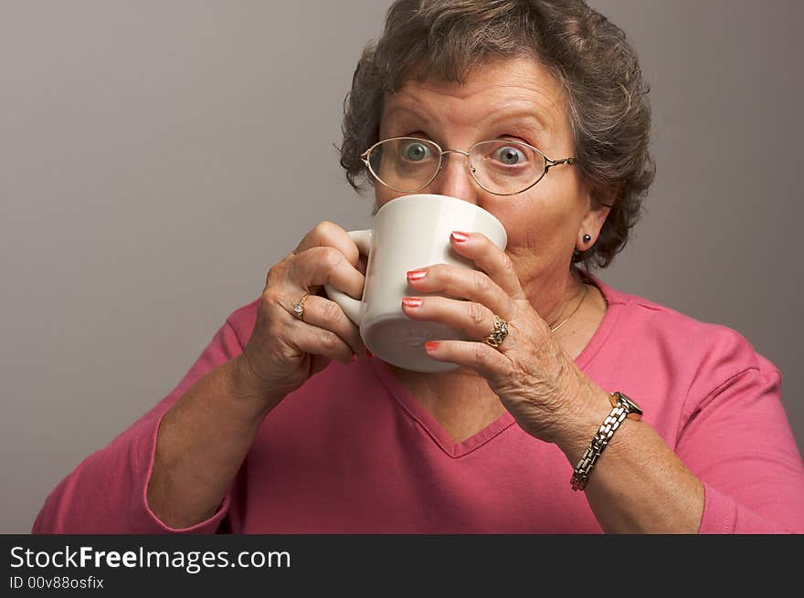 Elderly Woman Enjoys a Sip of Hot Coffee. Elderly Woman Enjoys a Sip of Hot Coffee