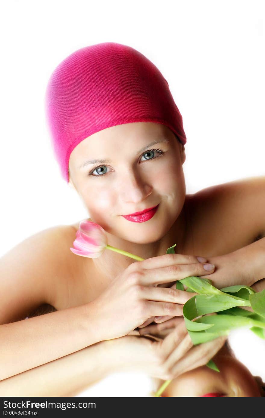 Beauty portrait of a young woman in pink with a tulip flower on a mirror. Beauty portrait of a young woman in pink with a tulip flower on a mirror