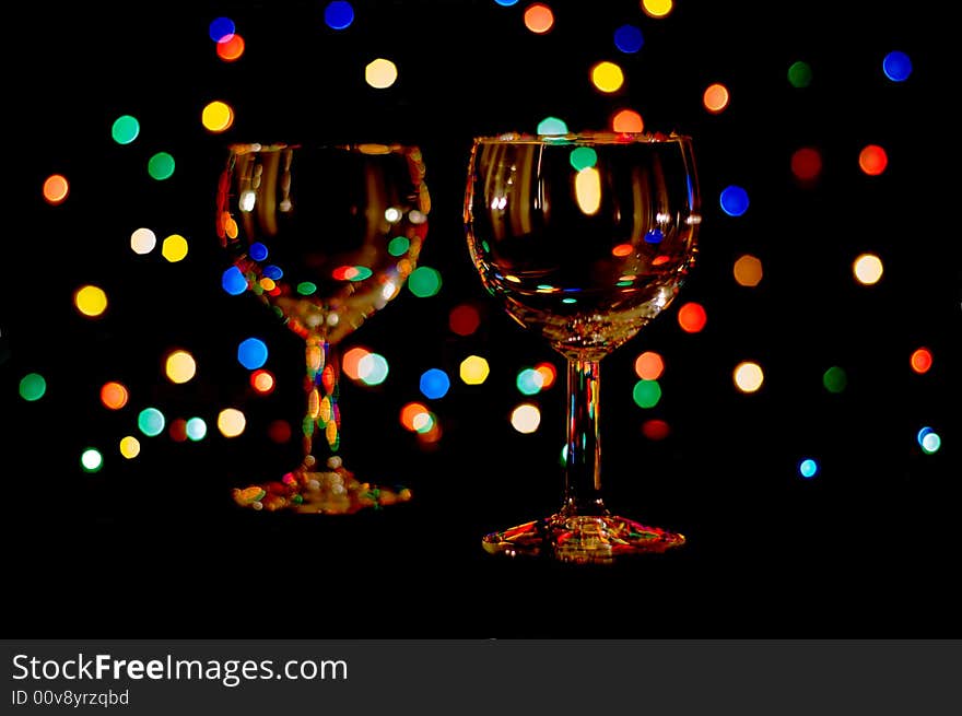 Two wine glasses with colored lens flares. Two wine glasses with colored lens flares