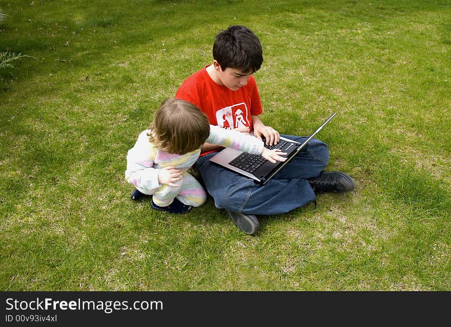 Boy and the girl with the laptop,in the garden. Boy and the girl with the laptop,in the garden