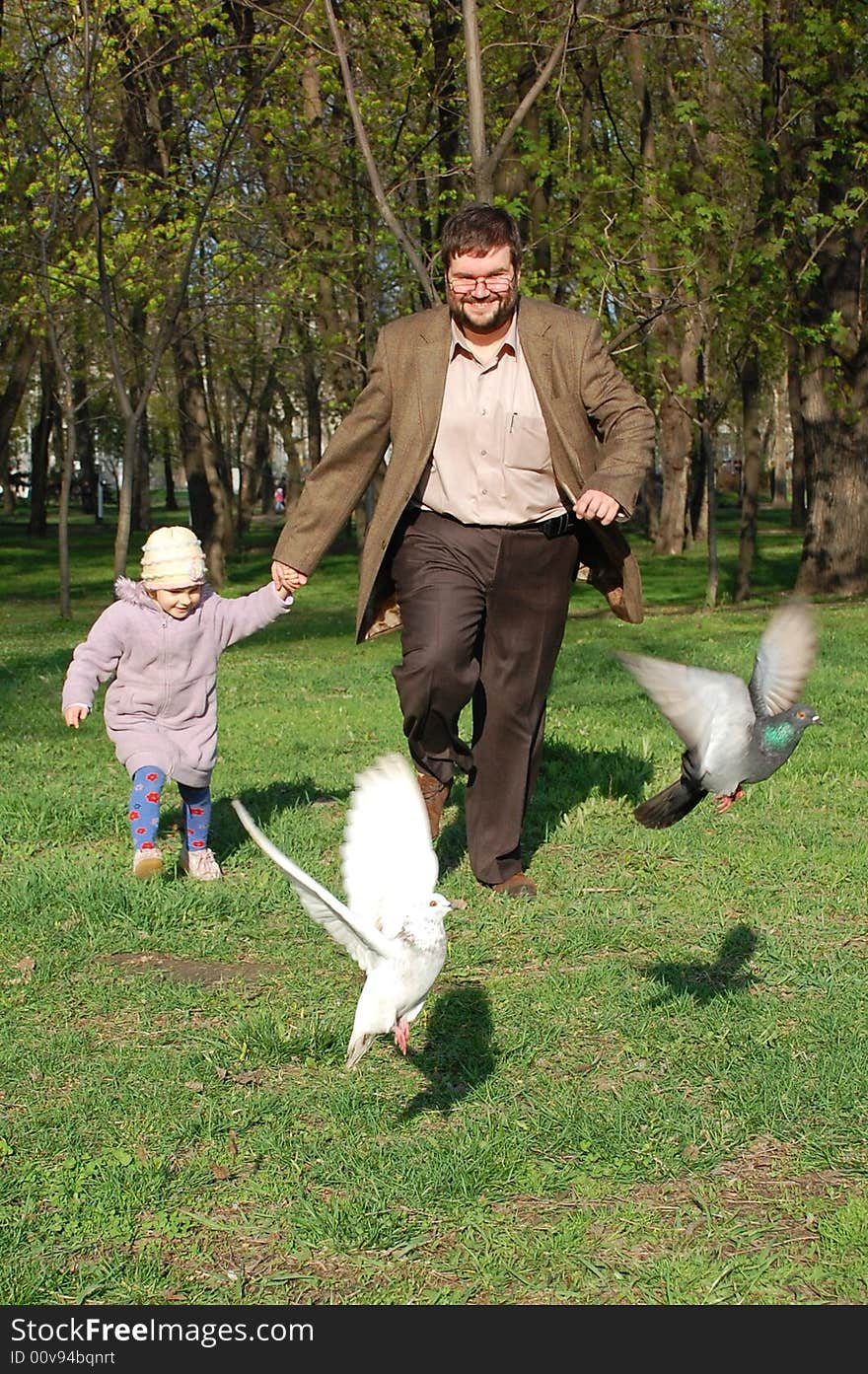 Man and girl running merrily forward holds their hands. Man and girl running merrily forward holds their hands