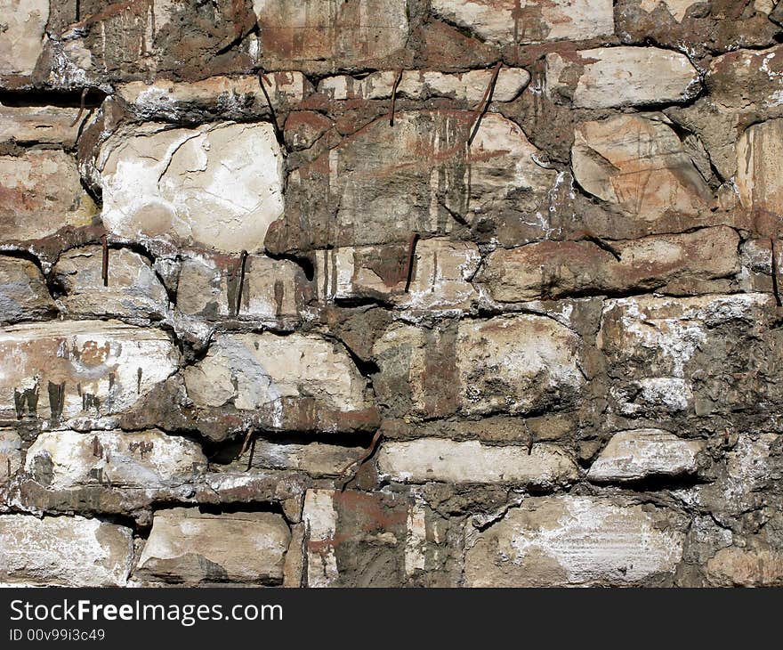 Piece of stone railway bridge pier surface with metal pins. Piece of stone railway bridge pier surface with metal pins