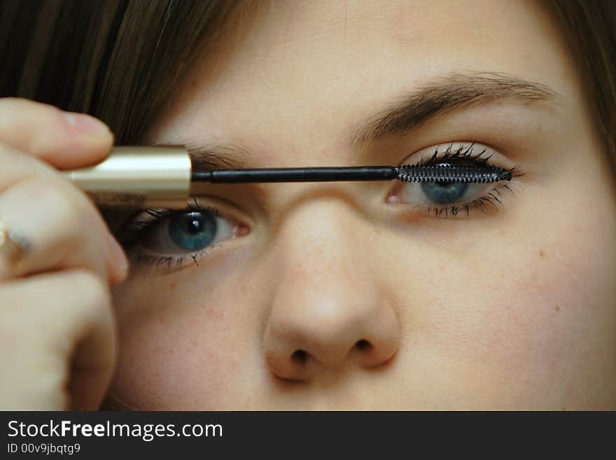 Young beautiful woman applying mascara. Young beautiful woman applying mascara