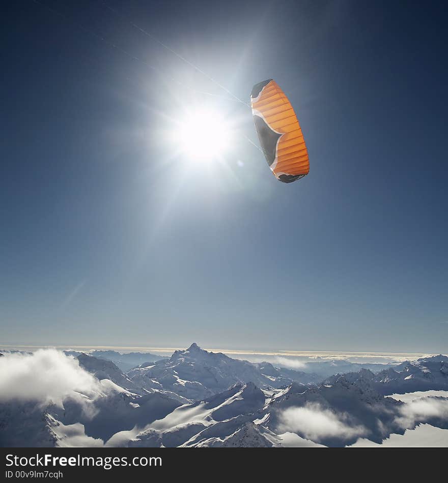 Winter mountains peaks kite and sun