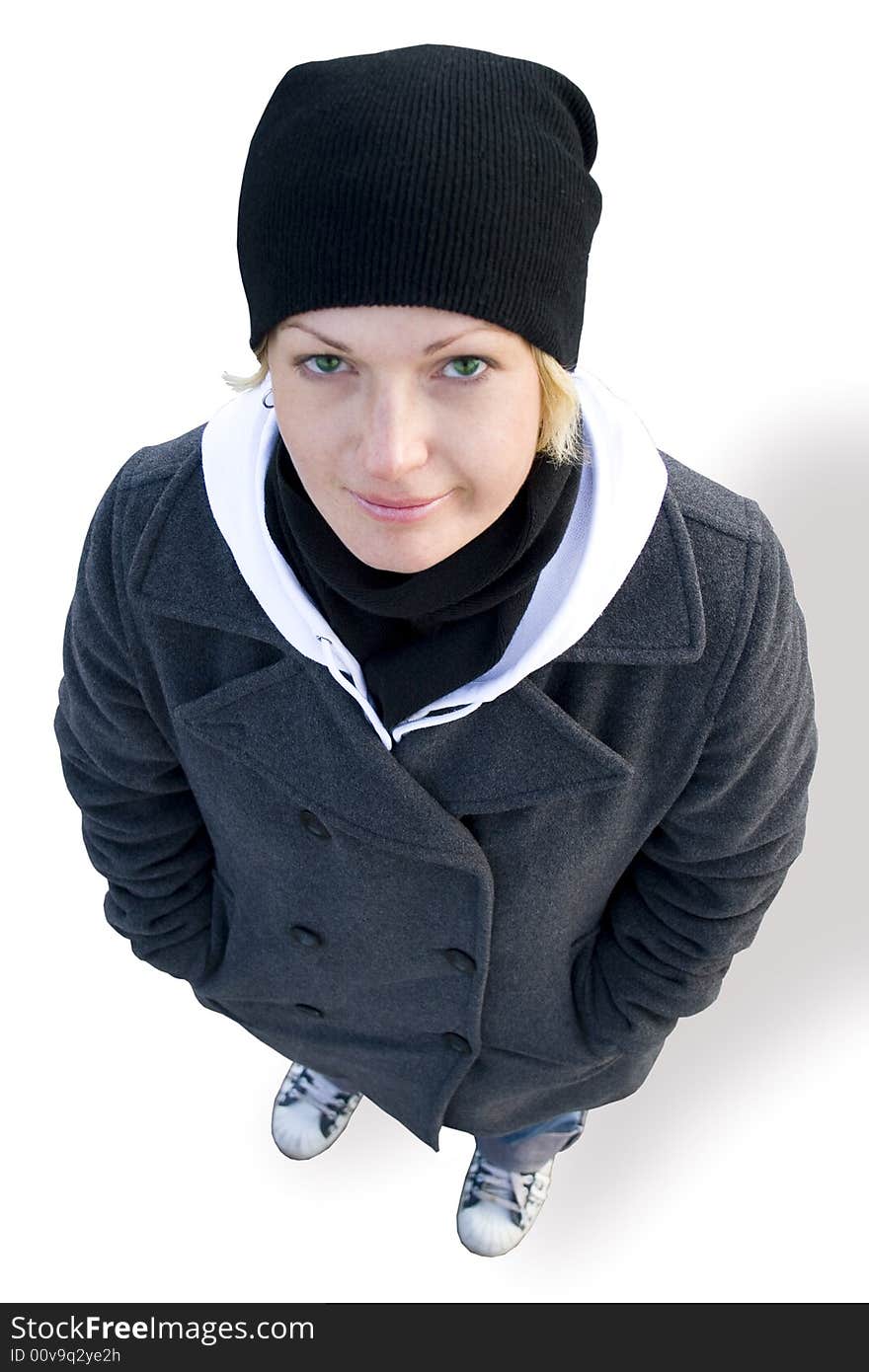 Girl in cap, coat and gym shoes on white background