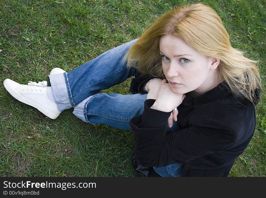 Pretty young blonde over green grass background