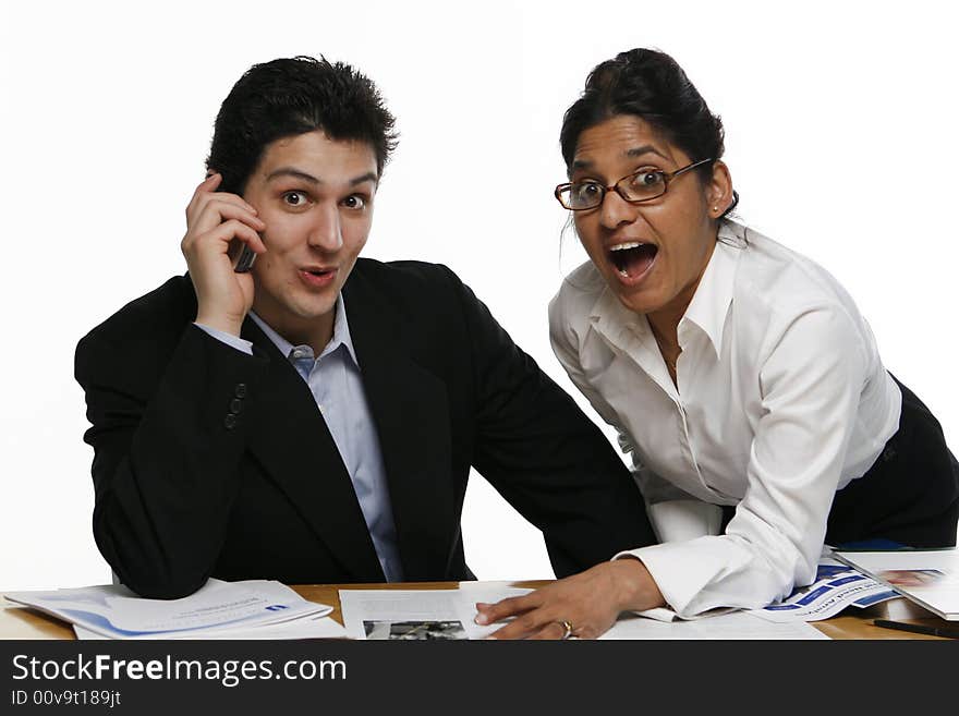 Male and female colleagues staring at the camera in surprise. Male and female colleagues staring at the camera in surprise