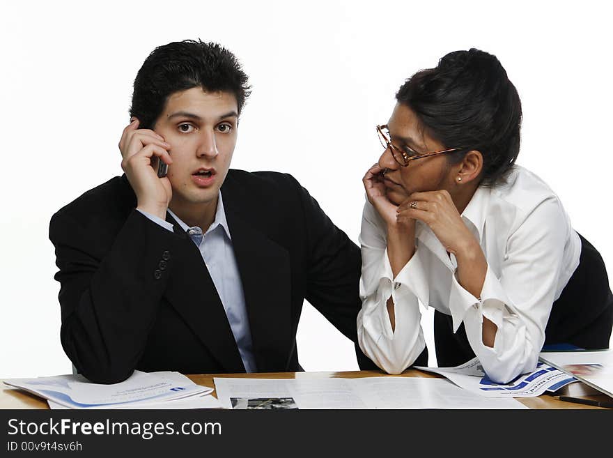 Male and female colleagues working together. He's getting bad news on the phone. Male and female colleagues working together. He's getting bad news on the phone