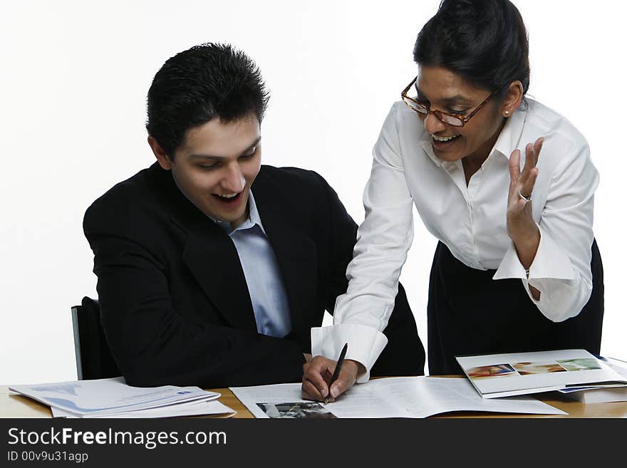 Male and female business colleagues with mouths open in excitement reviewing a document together. Male and female business colleagues with mouths open in excitement reviewing a document together