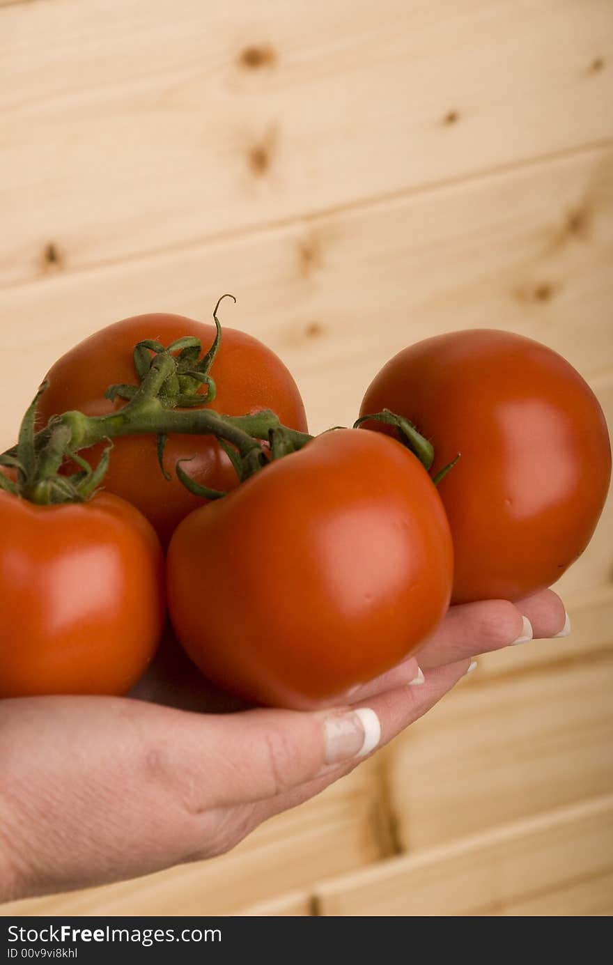 hand holding four organic tomatoes