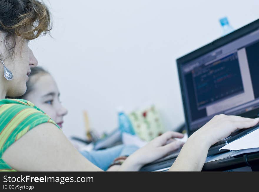 Teen girl learning computers from her sister