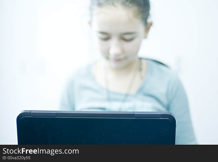 Little girl working on laptop computer. Focus on laptop. Little girl working on laptop computer. Focus on laptop