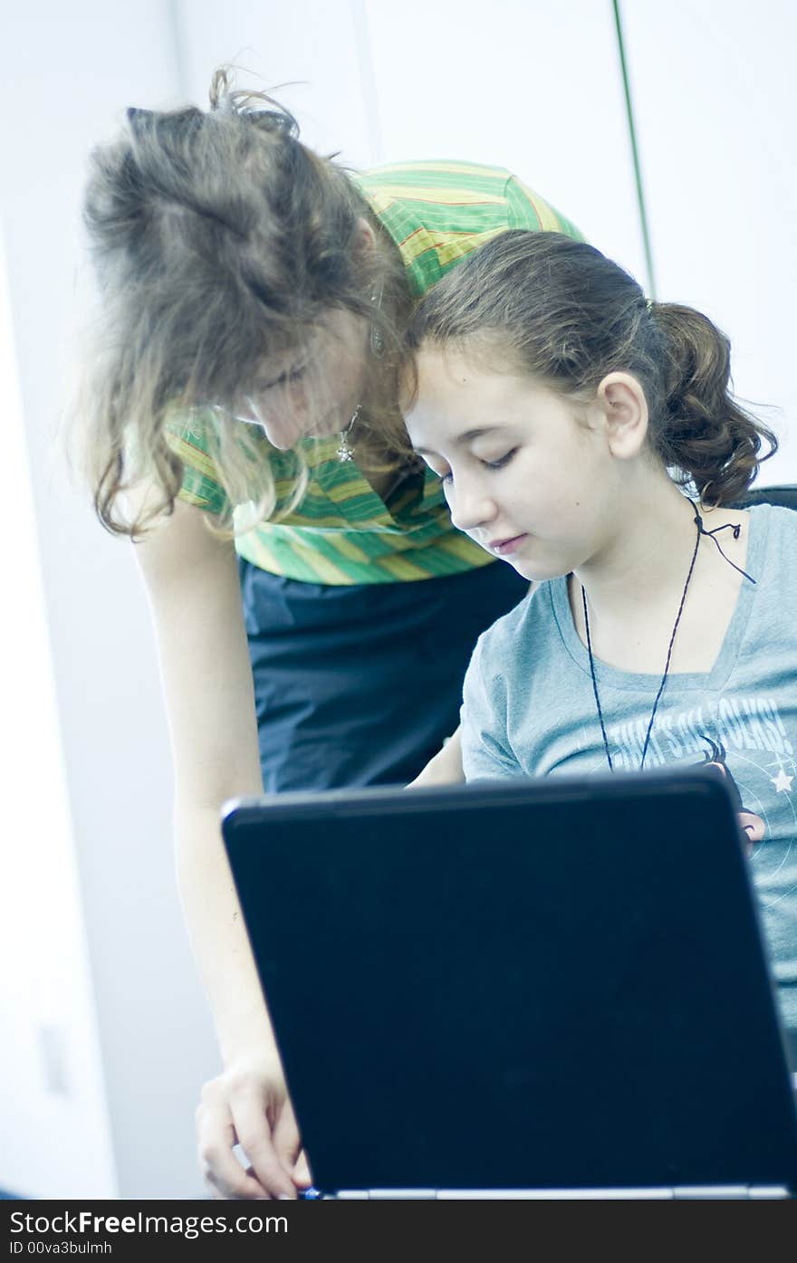 Teen girl learning computers from her sister