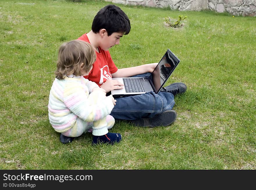 Boy and the girl with the laptop,in the garden. Boy and the girl with the laptop,in the garden