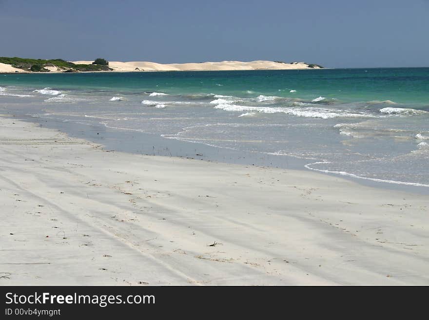 Wide angle shot of idyllic sandy beach with clear blue sky. Australia