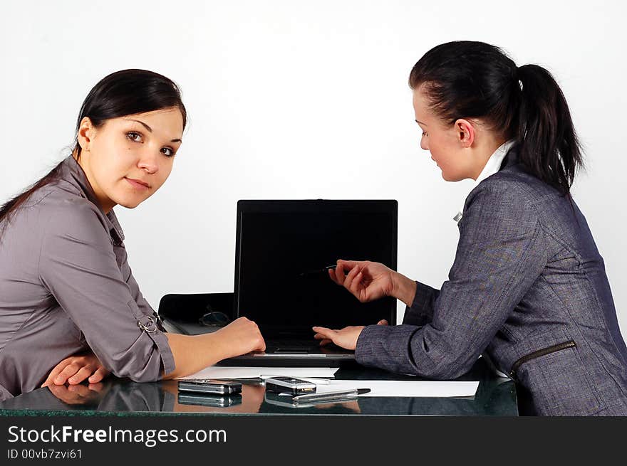 Two brunette women working in office. Two brunette women working in office