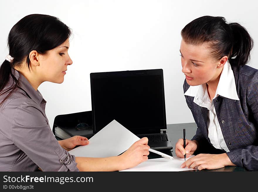 Two brunette women working in office. Two brunette women working in office