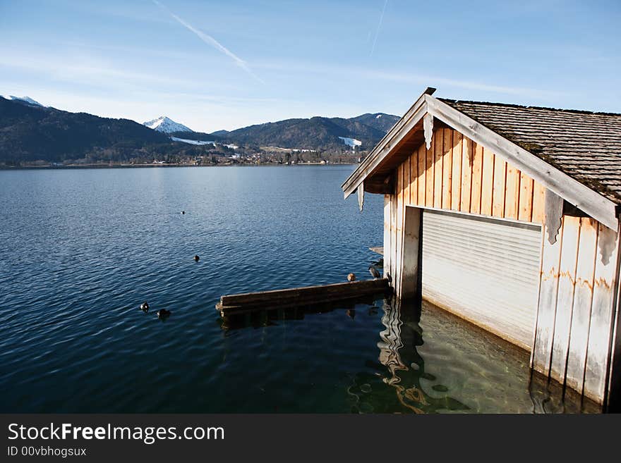 Boathouse at bavarian lake with view on mountains