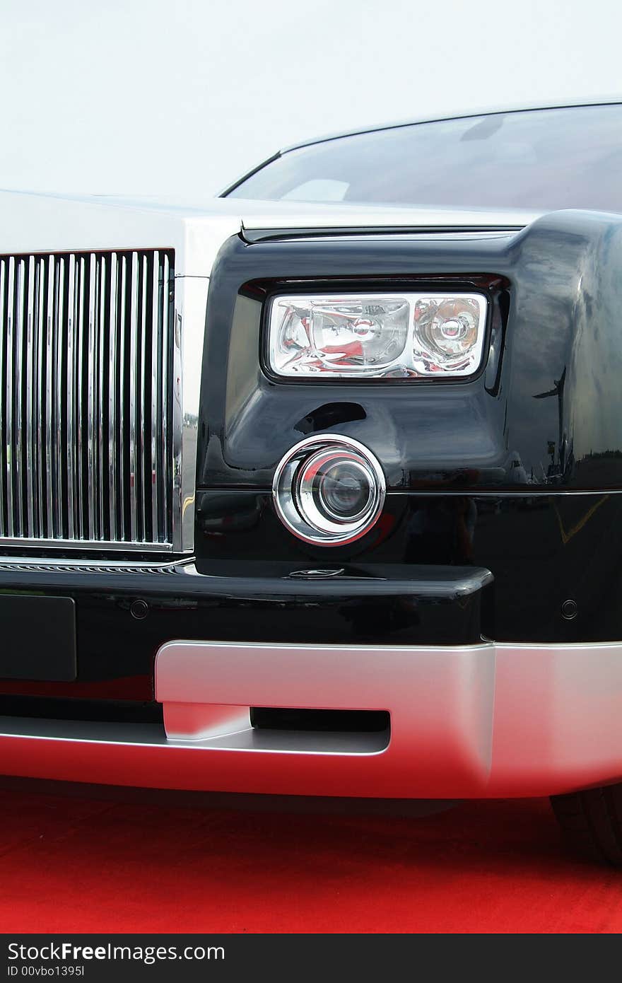 Black luxury car with chrome grill on a red carpet. Black luxury car with chrome grill on a red carpet.