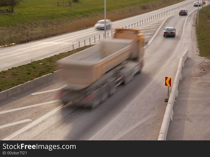 A truck travelling at high speed at the highway. A truck travelling at high speed at the highway