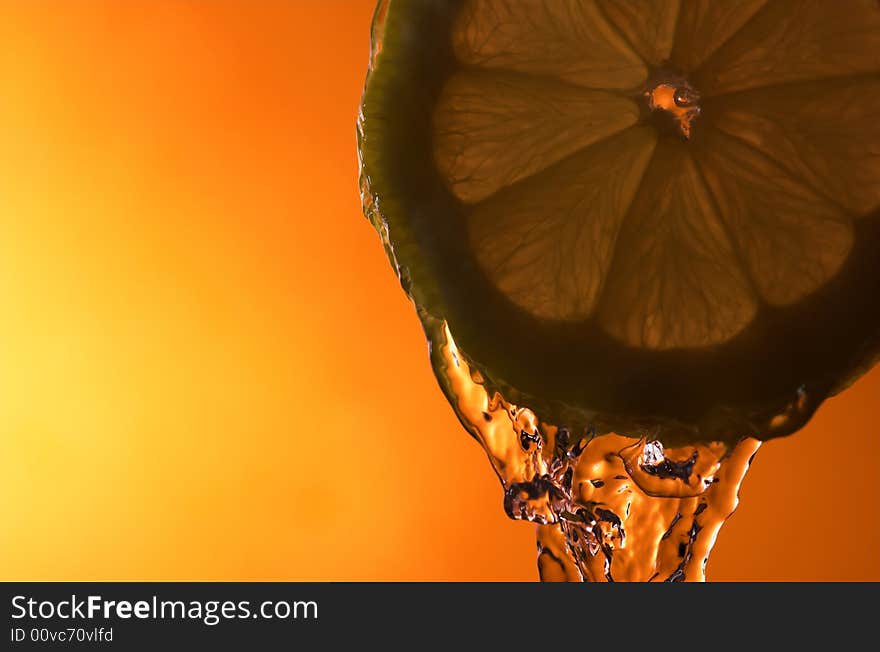 Lemon slice and water over orange background - back lit. Lemon slice and water over orange background - back lit