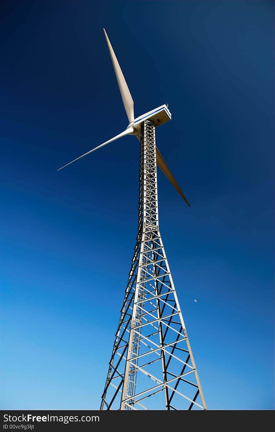 Wind turbine with deep blue sky and moon