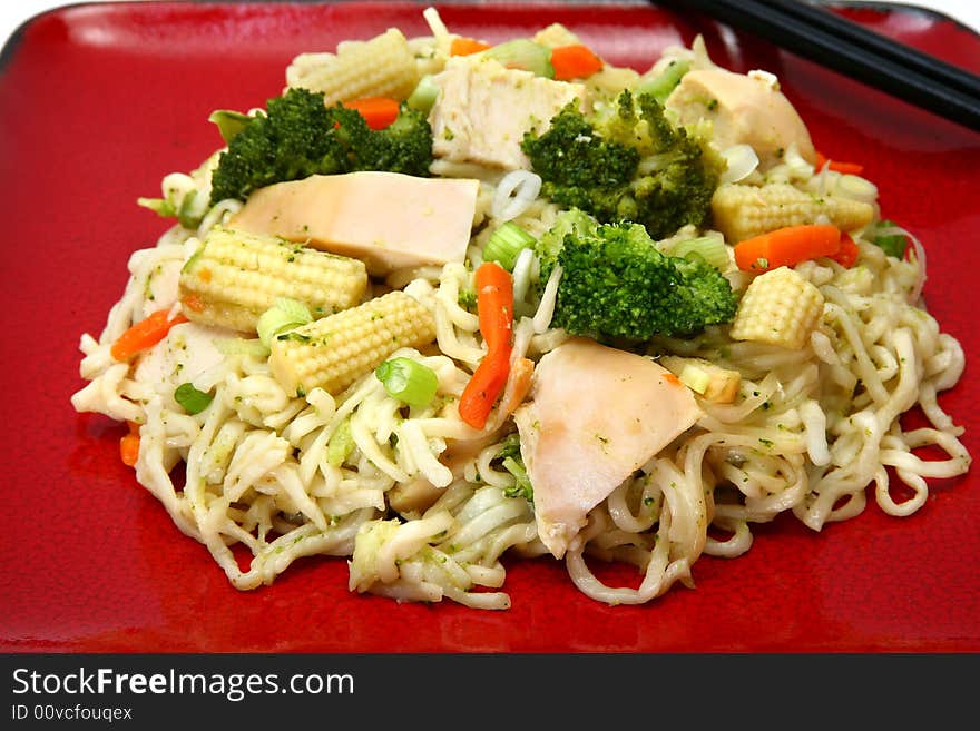 Plate of chicken stirfry with noodles and veggies.