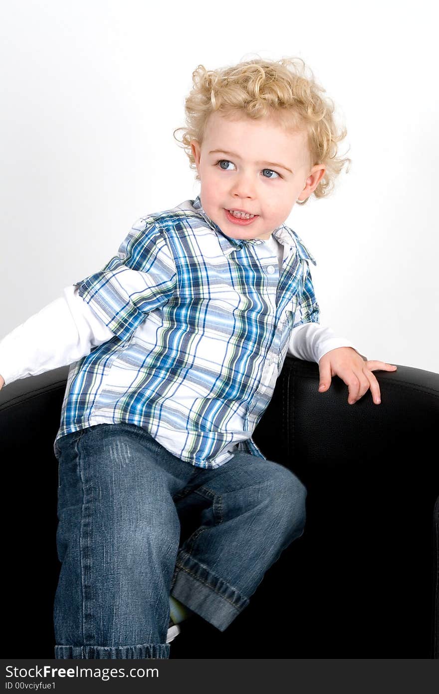 A young boy posing on a chair. A young boy posing on a chair