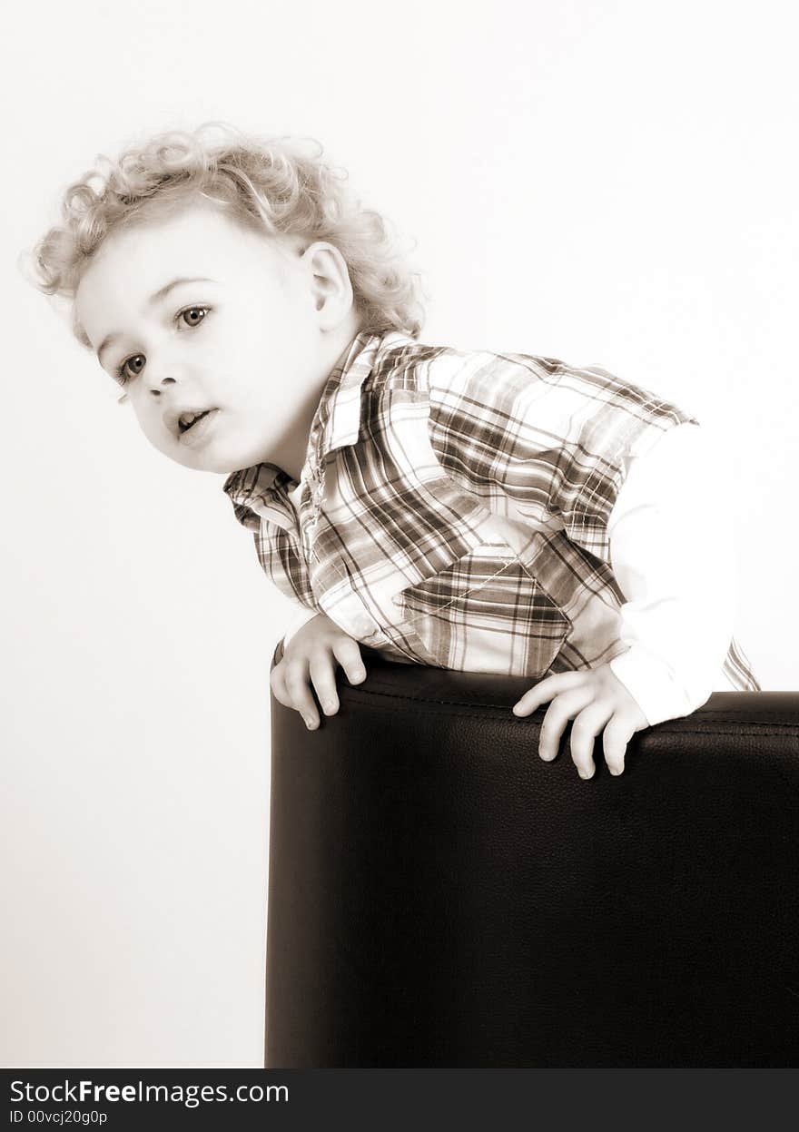 A young boy posing on a chair. A young boy posing on a chair