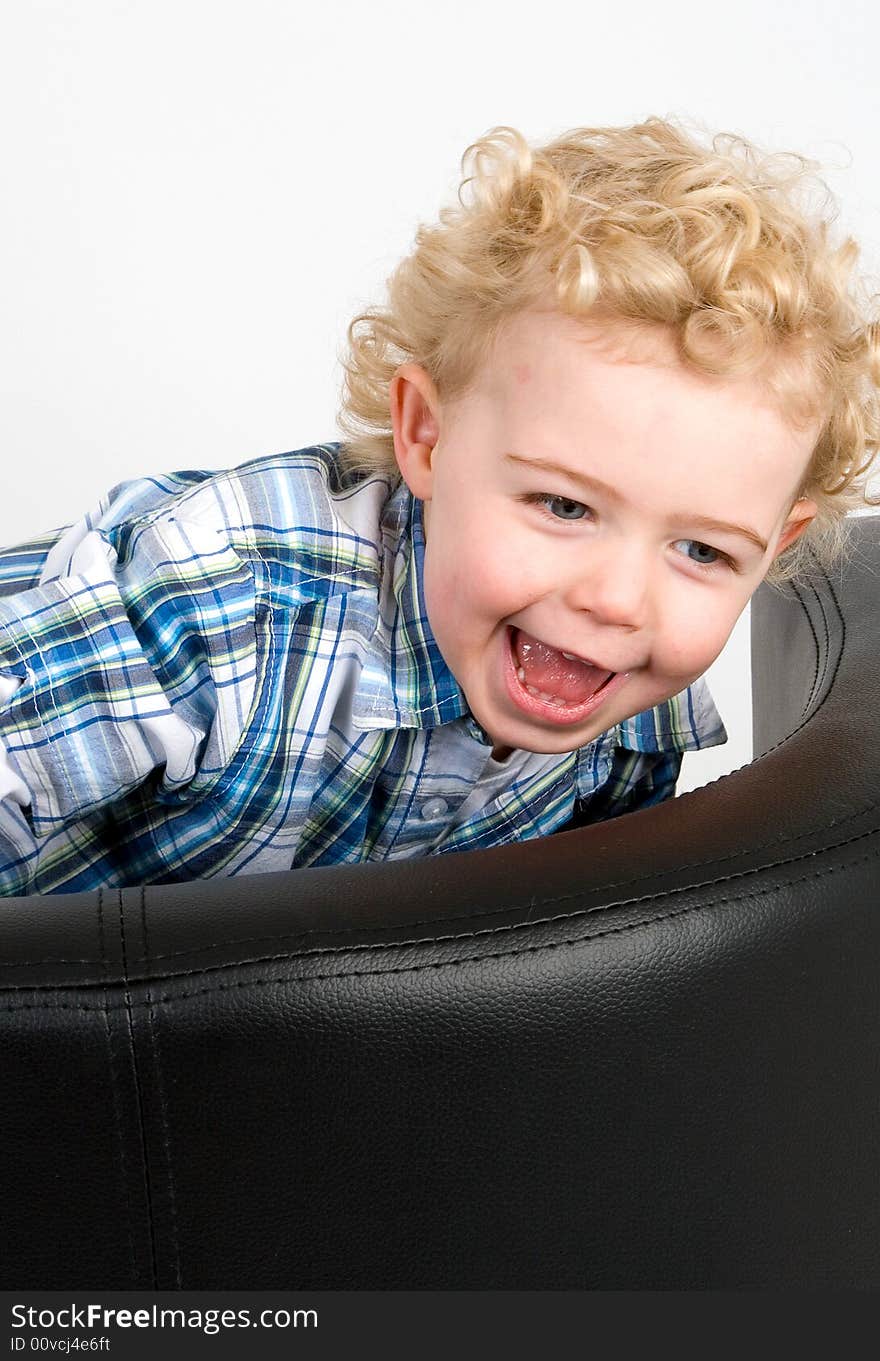 A young boy climbing on a  chair. A young boy climbing on a  chair