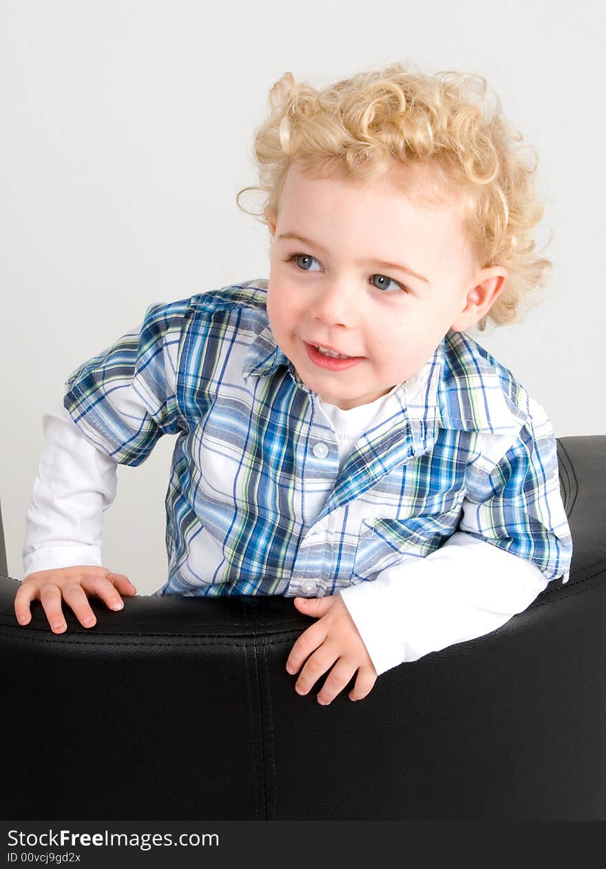 A young boy posing on a chair. A young boy posing on a chair