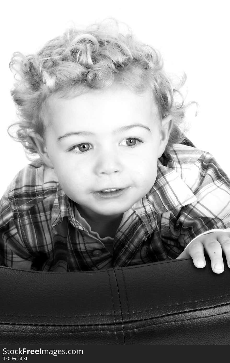 A young boy climbing up onto a chair. A young boy climbing up onto a chair