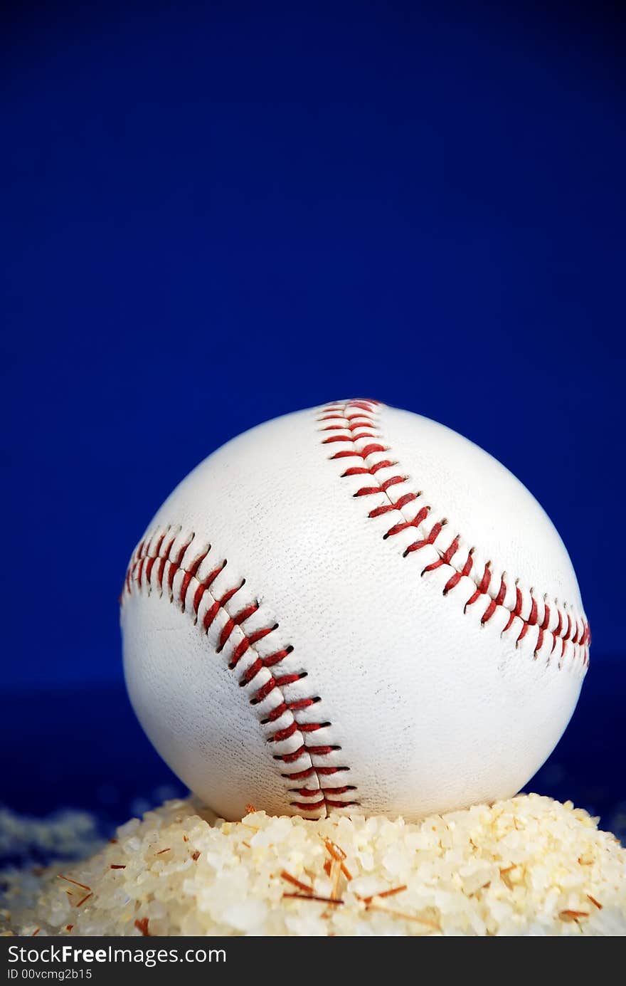 Baseball on sand hill with bluebacground