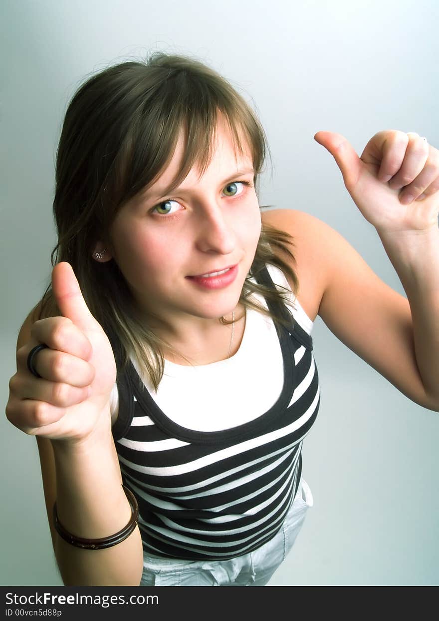 A pretty blond girl viewed from above and she shows her thumbs betoken her approval. A pretty blond girl viewed from above and she shows her thumbs betoken her approval