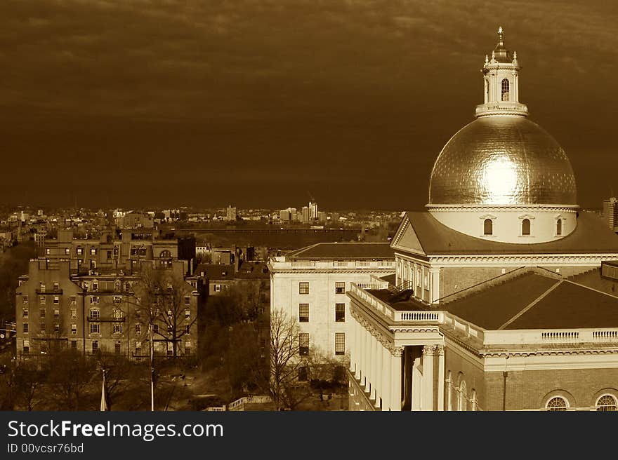 Clouds battel the sunshine as the golden dome of the massachusetts state house glows in this dramatic sepia toned image. Clouds battel the sunshine as the golden dome of the massachusetts state house glows in this dramatic sepia toned image