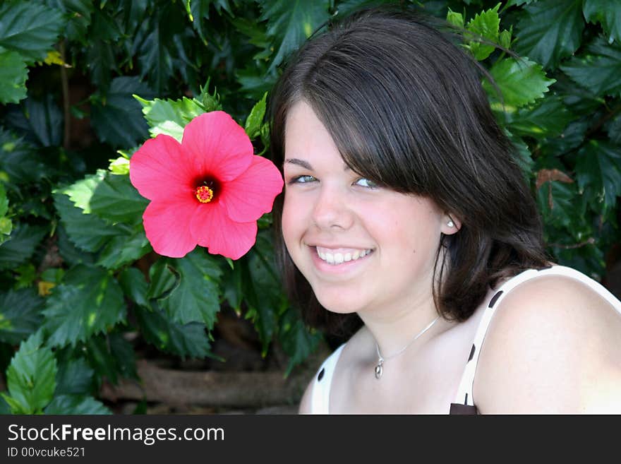 A 17 year old teenage girl posing for her senior portraits with a Hibiscus Plant. A 17 year old teenage girl posing for her senior portraits with a Hibiscus Plant.