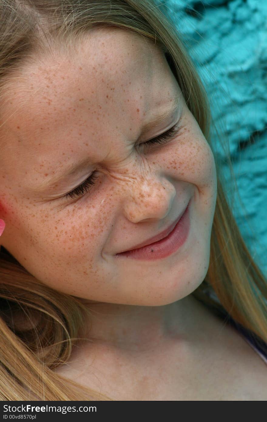 A white caucasian girl child with her eyes closed from the brightness. A white caucasian girl child with her eyes closed from the brightness