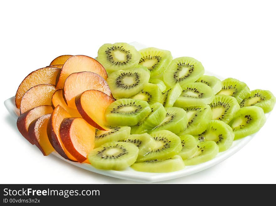 Sliced kiwi and plum on a plate. Isolated on a white background. Clipping path included.