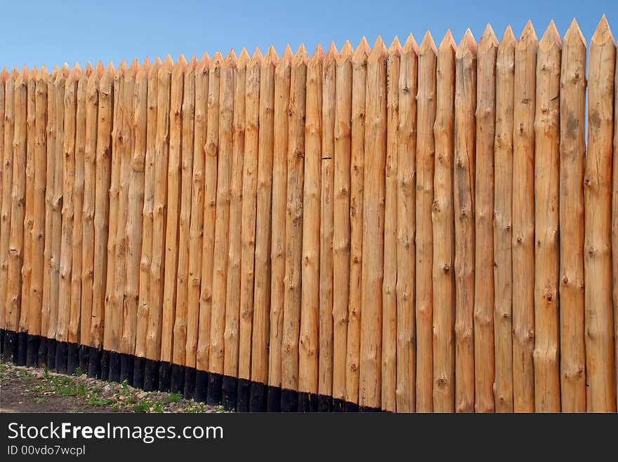 Wooden paling from the sharp raw logs