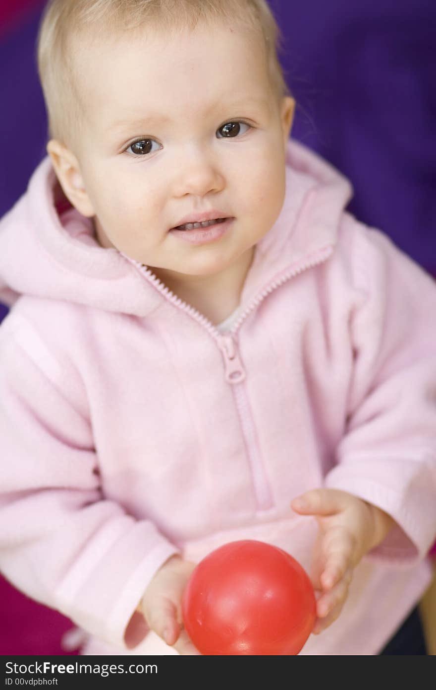 Girl with small ball on violet background