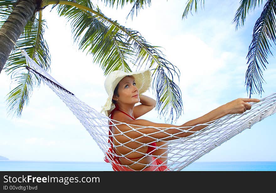 View of nice woman lounging in hammock in tropical environment. View of nice woman lounging in hammock in tropical environment